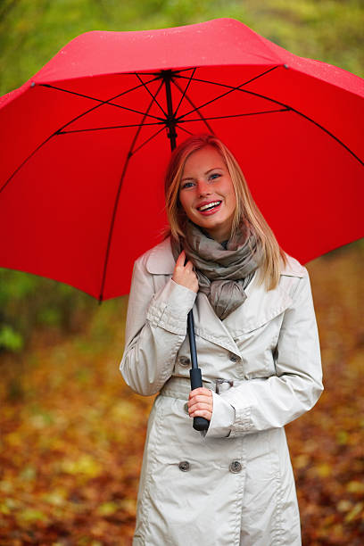istock woman standing outdoors with red umbrella 89514450