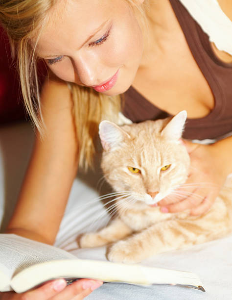 istock Young beautiful woman with a cat reading a book 89514511