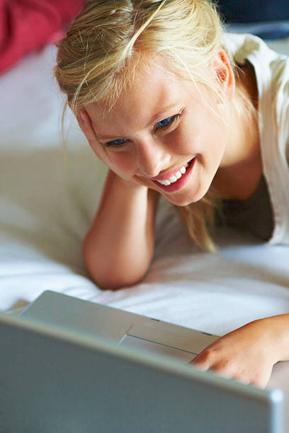 girl smiling and using a laptop