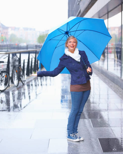young girl standing with a blue umbrella