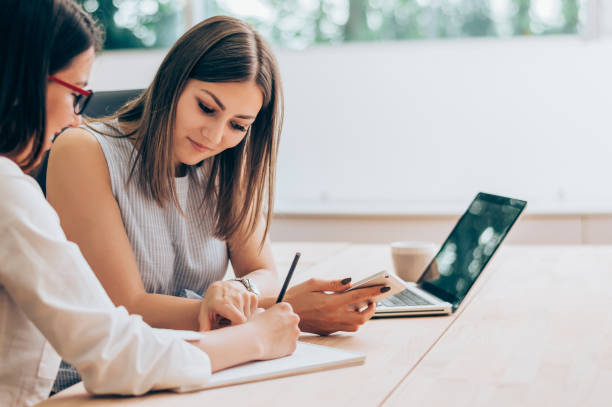 一緒に働くオフィスで 2 人の女性同僚。 - business meeting casual teamwork ストックフォトと画像