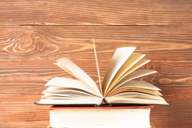 istock Open book, hardback books on wooden table. Education background. Back to school. Copy space for text. 895162654