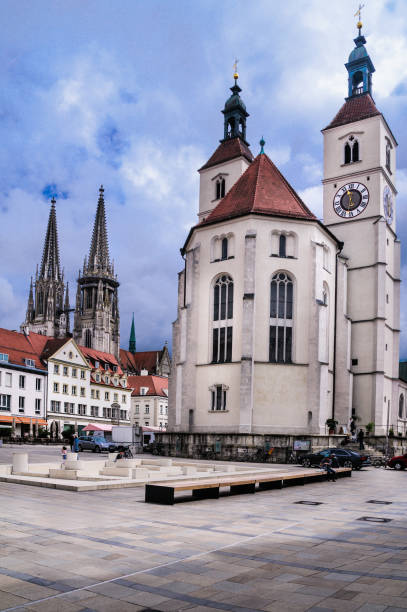 Regensburg, Germany -May 30, 2016- The  New Parish Church on Neupfarrplatz and the twin spires of the Regensburg Cathedrali n the background dominate the skyline of this old German City.