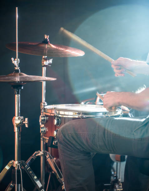 istock man plays the drum, flash of light, a beautiful light in the background with copy space 895174122