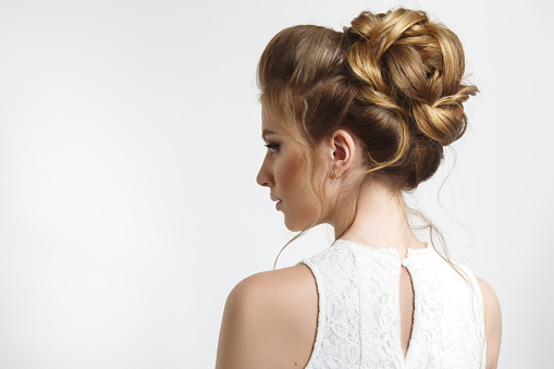 Elegant wedding hairstyle on a beautiful bride in profile.