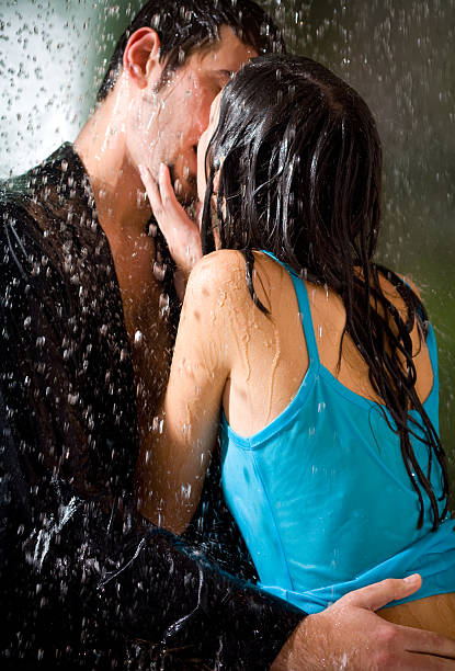 Jovem Casal a beijar justo sob uma chuva, na paixão - fotografia de stock