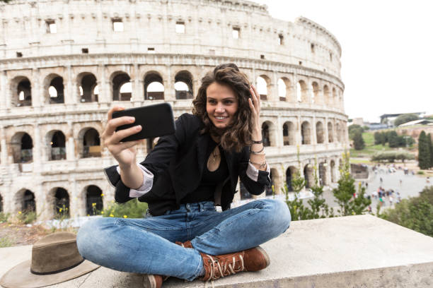 istock Young woman taking selfie in front of Coliseum 895263154