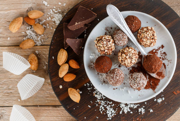 istock Prepare assorted dark chocolate truffles with cocoa powder, coconut and chopped almonds closeup. Homemade candy. Selective focus 895263470