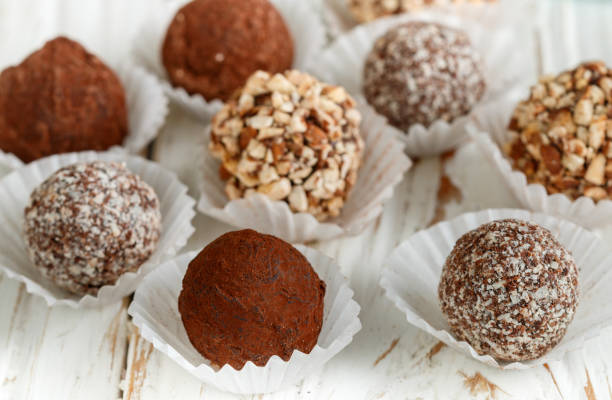 istock Assorted dark chocolate truffles with cocoa powder, coconut and chopped almonds closeup. Homemade candy. Selective focus 895263472