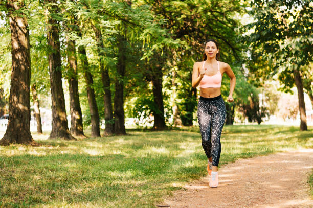 istock Female runner jogging during outdoor workout in a park. 895265968