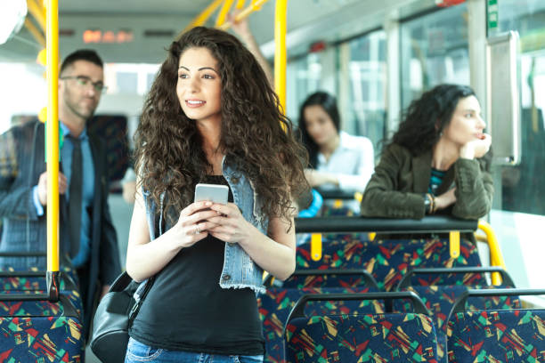istock Beautiful young woman using smart phone inside of a bus 895273278