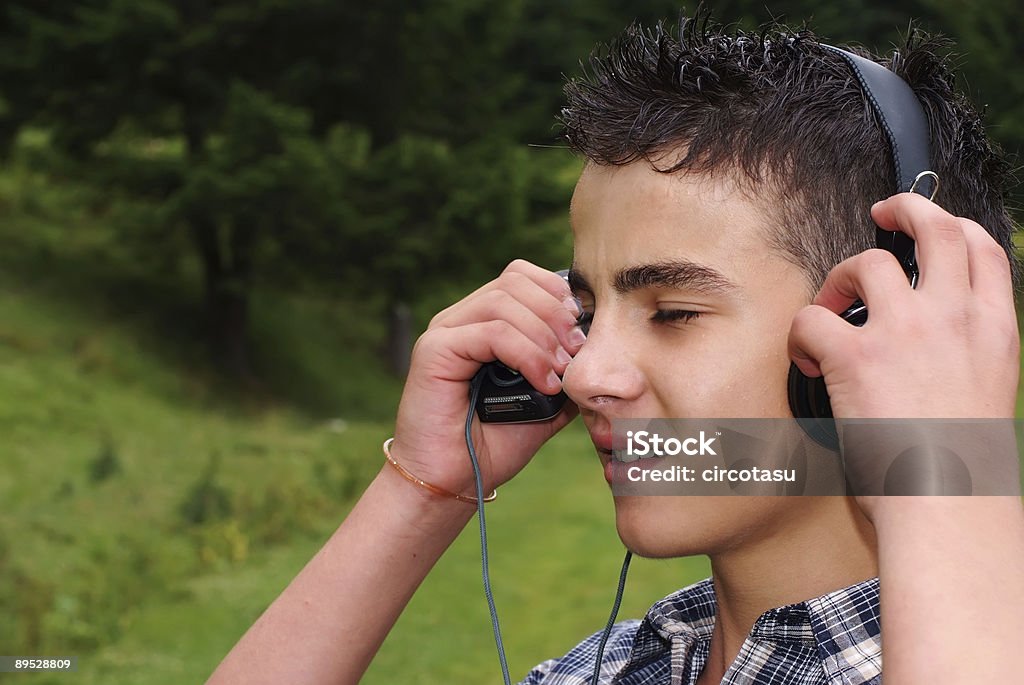 Giovane ragazzo godendo la musica - Foto stock royalty-free di Abbigliamento casual