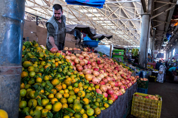 Agadir, Morocco, October 24, 2017: Man selling fresh fruits on Souk El Had, in the centre of Agadir. The market offers fresh fruit, vegatables, and traditional Moroccan goods.