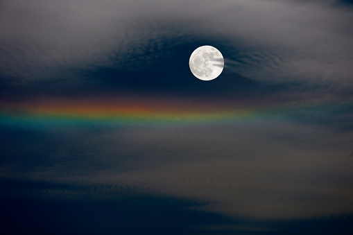 Full moon and iridescent clouds with copy space.