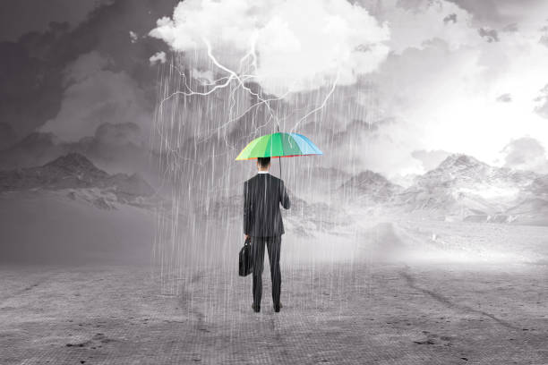 istock Businessman with umbrella in storm 895314930