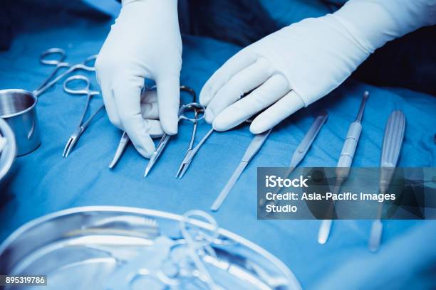 Closeup Of Scrub Nurse Taking Medical Instrumentssurgery And Emergency Concept Stock Photo - Download Image Now
