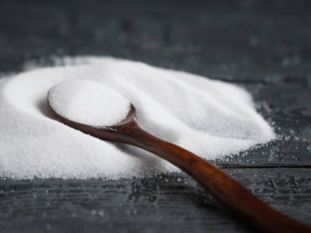 istock White salt, finely ground scattered on a wooden table with a spoon. 895345560