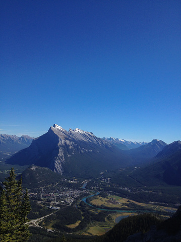 View of iconic Mount Rundle near the Banff townsite in Banff National Park, taken across the valley from the top of a nearby mountain.