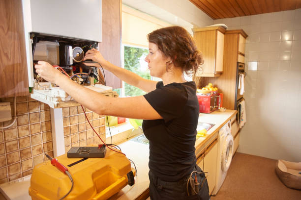 feminino canalizador, reparação de uma caldeira - plumber electrician trainee female - fotografias e filmes do acervo