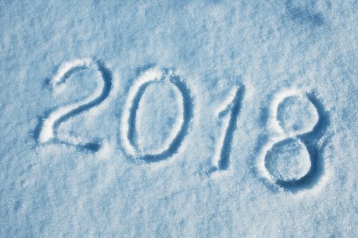 New Year 2018 written on the snow (in blue tones). Close-up DSLR photo with nice real snow texture.
