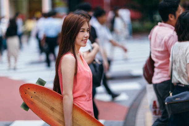 istock Young Woman Walking With Her Skateboard 895379246