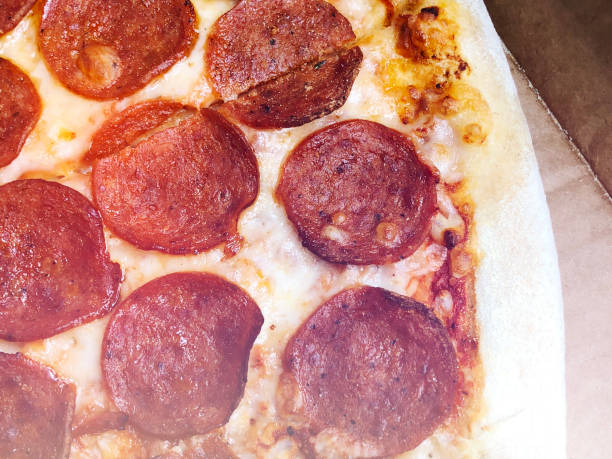 istock Close-up thinly sliced pepperoni on fresh Italian classic original Pizza. 895384388