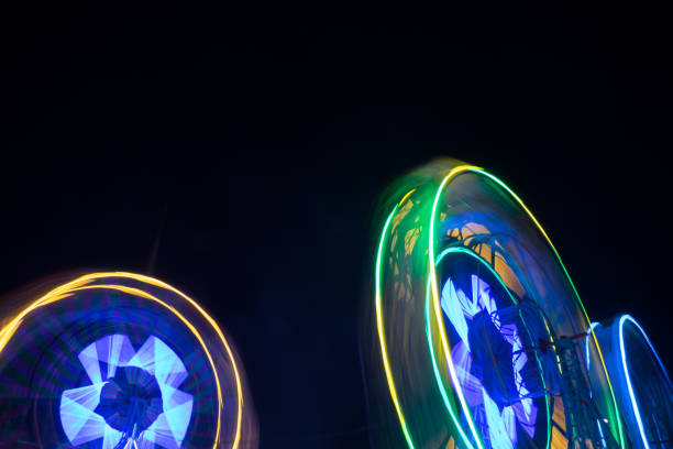 istock Spinning ferris wheel at night - Long exposure blurred motion 895384652
