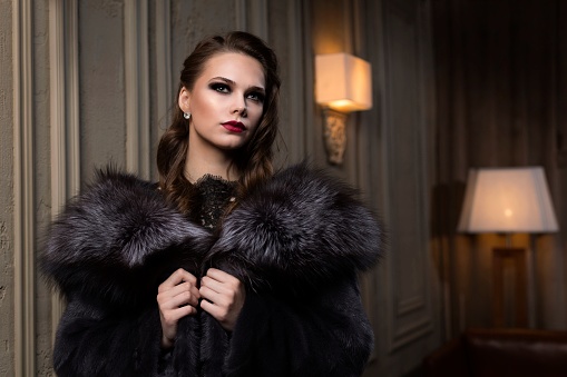 beautiful girl in a fur coat came to a party in a restaurant