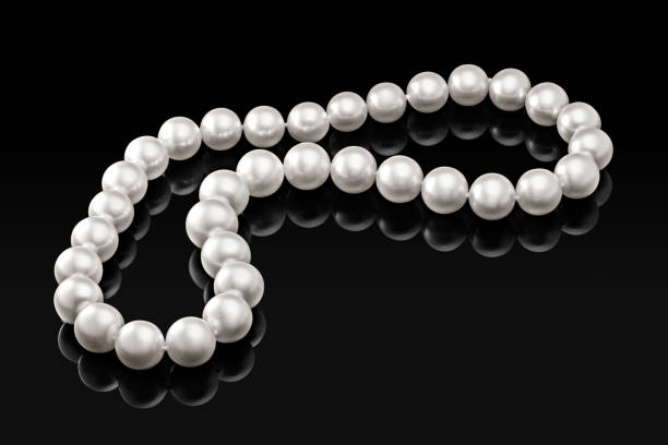 istock Luxury white pearl necklace on a black background with glossy reflection 895392018