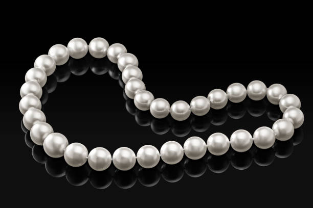istock Luxury white pearl necklace on a black background with glossy reflection 895392064