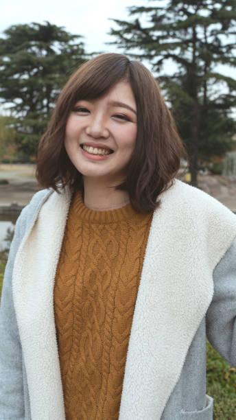 istock Front view of young woman standing outdoors and smiling 895398638
