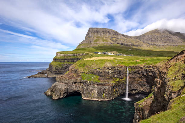Mulafossur Waterfall with great Landscape.The little village Gasadalur on Faroe Islands Mulafossur Waterfall with great Landscape.The little village Gasadalur on Faroe Islands with the Mulafossur Waterfall. mykines faroe islands photos stock pictures, royalty-free photos & images
