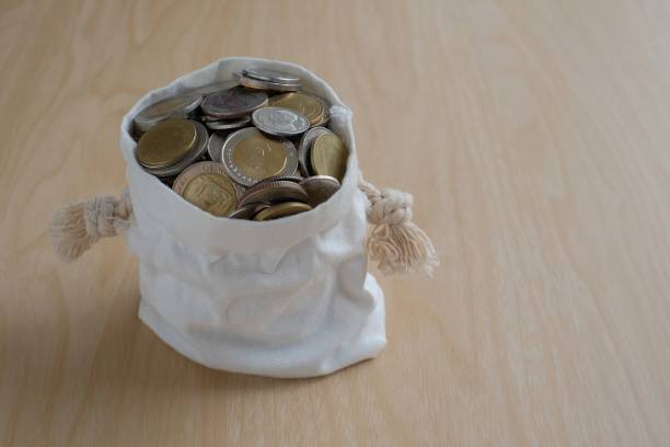 istock Coins in fabric bag wooden background 895401056