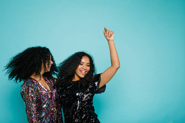 istock Two women with black curly hair dancing in studio, having fun 895422622