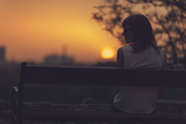 istock Woman sitting on a bench and watching the distant city scenery. 895427478