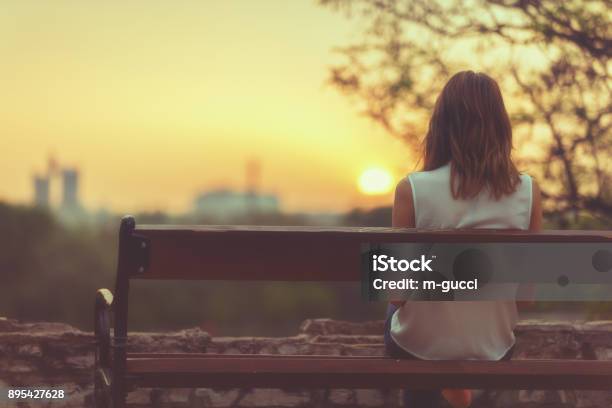 Woman Sitting On A Bench And Watching The Distant City Scenery Stock Photo - Download Image Now