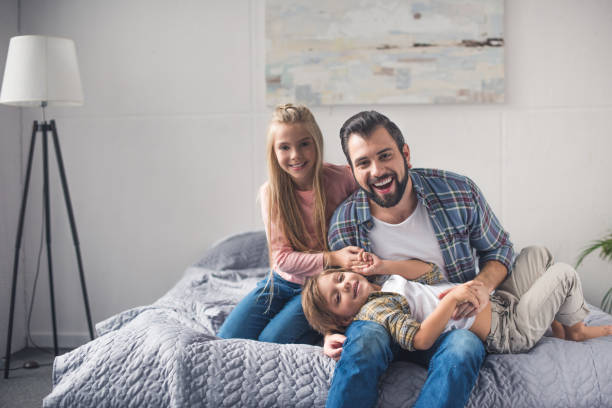 istock father and kids resting on bed 895440898