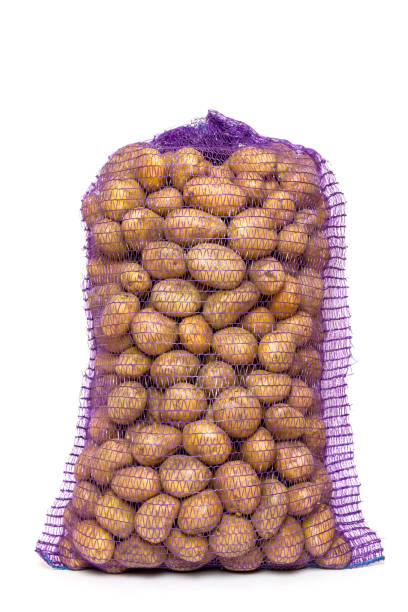 a bag of raw and dirty potatoes. - onion bag netting vegetable imagens e fotografias de stock