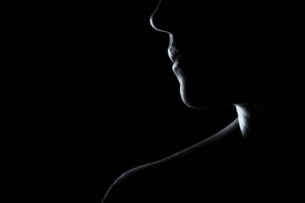 Silhouette of a woman face in black and white with rim lighting stock photo