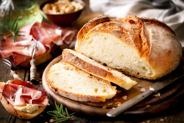 Loaf of rustic homemade bread with prosciutto ham stock photo