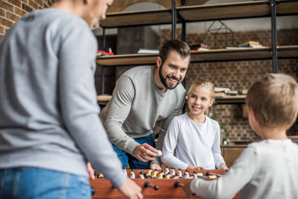 istock parents and kids playing table football 895451862