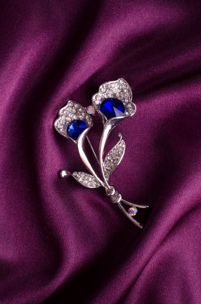 istock silver brooch flower with blue stone on silk 895454364