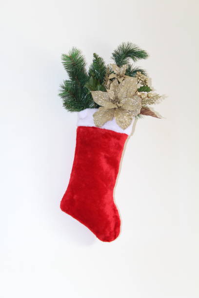 istock Stocking filled with gold glittered flowers and pine branch 895465862