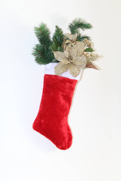 istock Sparkling gold flowers and pine branch filled holiday stocking 895465902