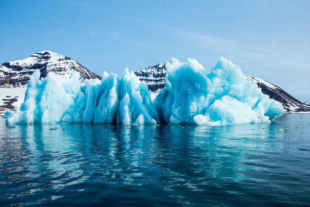 'Blue iceberg floating in the Hornsund Spitzbergen. Blue ice is very old ice, which was under pressure by the glacier. The cloudy, fogy weather is typical for the north and the light show the wide spectrum of the blue colors.'