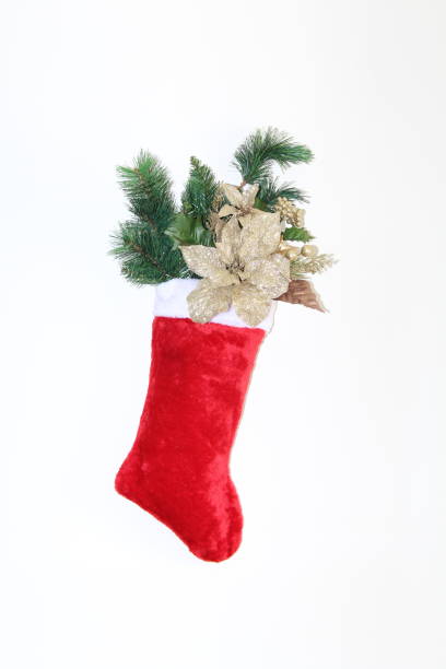 istock Red Christmas stocking filled with flowers and pine 895466084