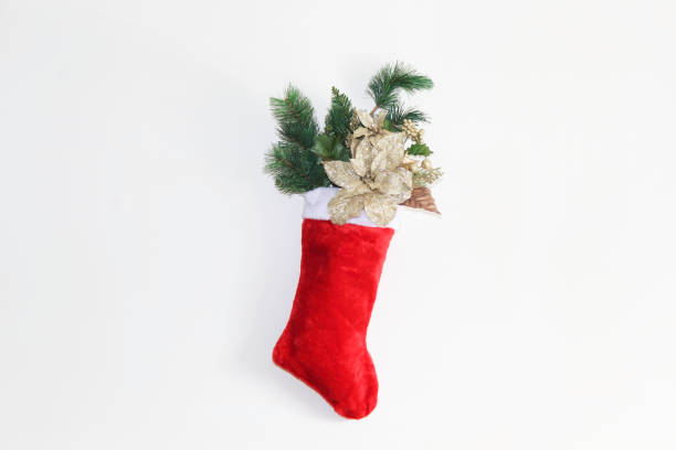 istock Red Christmas stocking filled with flowers and pines 895466086