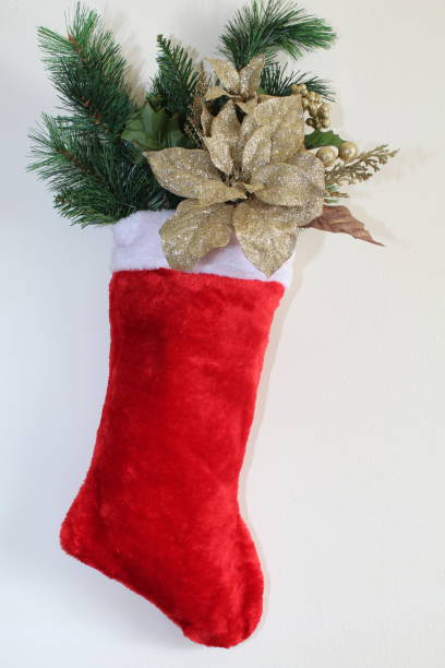 istock Christmas stocking filled with gold flowers and berries 895466144