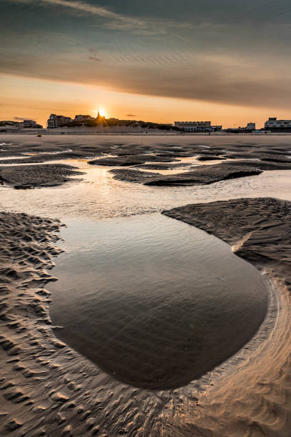 istock Sunrise on the puddles and pools left by the low tide on the beach. 895472244