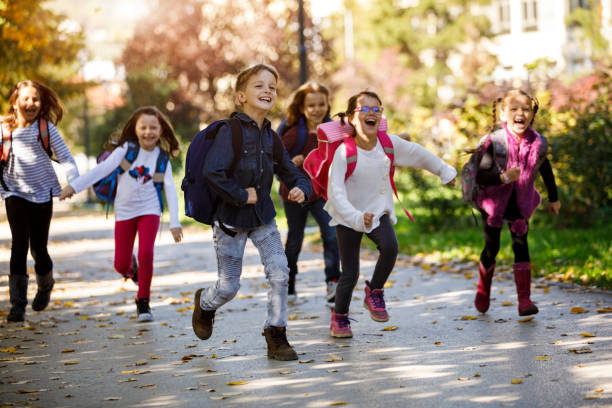 niños de la escuela en el patio de la escuela - niño de edad escolar fotografías e imágenes de stock